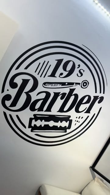 Logo de 19's Barber pintado en la pared de la barbería